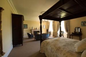 - une chambre avec un lit à baldaquin et une cheminée dans l'établissement Château de Valette, à La Bachellerie