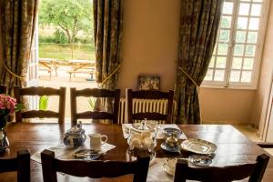uma sala de jantar com uma mesa e cadeiras e uma janela em Château de Valette em La Bachellerie