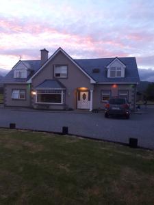 una casa con un coche aparcado en una entrada en Wild Atlantic Stays, en Castlemaine