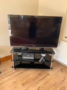 a large flat screen tv on a black stand at Penddaulwyn Uchaf Farm # Carmarthenshire in Nantgaredig