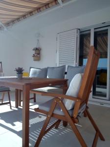mesa de comedor de madera con silla y sofá en Apartmani More Komarna, en Komarna