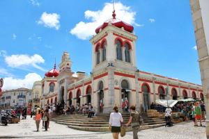 a group of people walking around a building with a tower at Porta 20 in Loulé