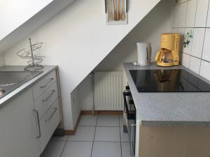 une cuisine avec un escalier et un comptoir dans l'établissement Résidence de l’ex hôtel des roches, à Plancher-les-Mines