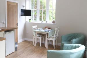 a kitchen with a table and chairs and a window at Rose Barn in West Lavington
