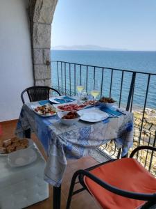 een tafel met eten op een balkon met uitzicht op de oceaan bij Albatros House in L'Escala