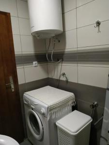 a laundry room with a washing machine and a toilet at Rijeka Rezevici Apartment in Reževići