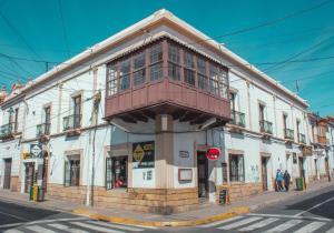 a building with a balcony on the corner of a street at Colors House in Sucre