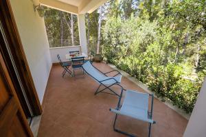 een patio met stoelen en een tafel op een veranda bij Casale la Macina Residence Scopello in Scopello