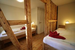sypialnia z 2 łóżkami piętrowymi i czerwonymi łukami w obiekcie Ferienwohnungen Felsenkeller Bielatal w mieście Bielatal