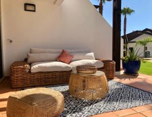 um sofá de vime e uma mesa no pátio em Luxury T2 in Vila Sol Village em Vilamoura