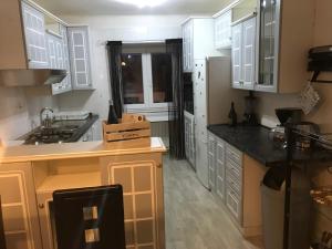 a kitchen with white cabinets and a sink and counters at Kuća za odmor City Oasis in Rijeka