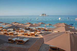 una playa con sombrillas y sillas y el océano en Hotel Riva by Aycon en Petrovac na Moru