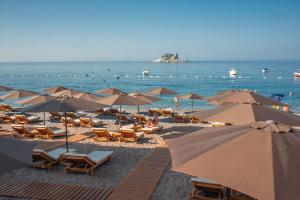 a beach filled with lots of umbrellas and chairs at Hotel Riva by Aycon in Petrovac na Moru