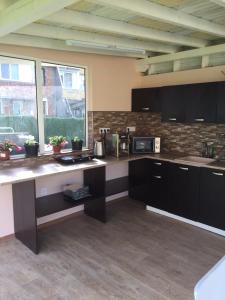 a large kitchen with black cabinets and a window at Family Hotel Malibu in Chernomorets