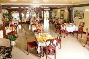 uma sala de jantar com mesas e cadeiras num restaurante em Hotel Olimpico en Quevedo em Quevedo