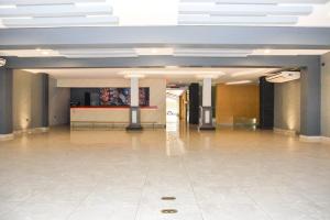 a large empty room with a tile floor in a building at Hotel Olimpico en Quevedo in Quevedo