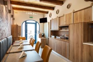 a restaurant with wooden tables and chairs and a kitchen at The Shipwright's Lodge in Marsaxlokk
