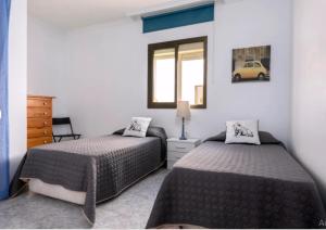 a bedroom with two beds and a window at Casa Sandra in Corralejo