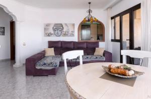 a living room with a purple couch and a table at Casa Sandra in Corralejo