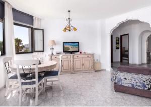 een woonkamer met een tafel en een slaapkamer bij Casa Sandra in Corralejo