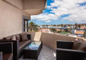 een balkon met een bank en een glazen tafel bij Casa Sandra in Corralejo