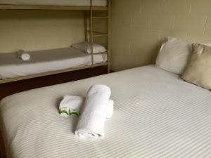1 cama con 2 literas y toallas. en Koala Beach Resort Cairns, en Cairns