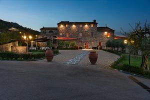 una grande casa in pietra con luci su un vialetto di Hotel Villa Volpi a Lucca