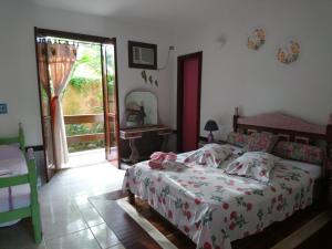 a bedroom with a bed and a large window at Pousada Brasil Paraty in Paraty