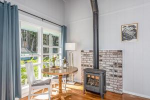 a living room with a wood stove and a table at Inn at Schoolhouse Creek in Mendocino