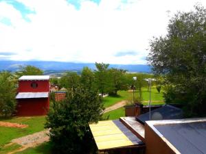 a view of a yard with a red building and a house at Puesto Potrillos in Villa Yacanto