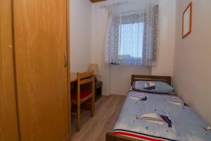 a small bedroom with a twin bed and a desk at Hostel Flora in Mali Lošinj