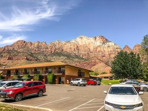 a parking lot with cars parked in front of a mountain at Bumbleberry Inn in Springdale