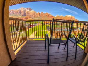 a balcony with a chair and a view of the mountains at Bumbleberry Inn in Springdale