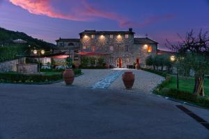duży kamienny dom z oświetleniem na podjeździe w obiekcie Castello Di Mammoli w Lukce