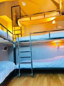 two bunk beds in a dorm room with a ladder at Maison d'architecte en plein cœur d'Honfleur avec bain nordique in Honfleur