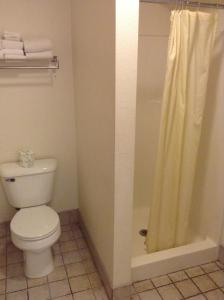 La salle de bains est pourvue d'une douche et de toilettes. dans l'établissement Coeur D' Alene Budget Saver Motel, à Coeur d'Alene