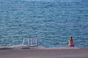 a woman standing on the beach looking at the water at The Wave in Sidari
