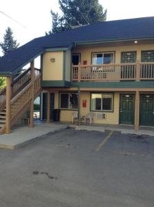 a large house with a balcony and a parking lot at Coeur D' Alene Budget Saver Motel in Coeur d'Alene