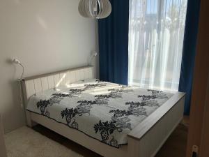 a bed with a black and white comforter and a window at Jõe Apartments in Tallinn