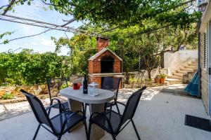 a table and chairs on a patio with a dog house at Great view apartment in Sutivan