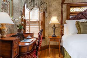 ウッドストックにあるThe Village Inn of Woodstockのベッドルーム1室(ノートパソコンとベッド1台付きのデスク付)