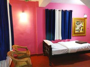 1 dormitorio con paredes de color rosa y azul y 1 cama en VAISHNAVI VILLA-WiFi-Home Food-Family Only-Kitchen Access-No TV, en Madikeri