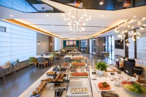 a buffet line with food on display in a restaurant at Atour Hotel Weifang Jinma Road City Hall in Weifang