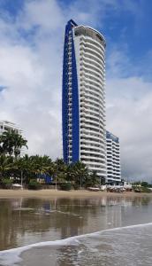 um edifício alto na praia junto ao oceano em Grand Diamond con Vista al Mar em Tonsupa