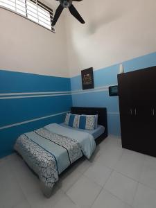 a bedroom with a bed with a ceiling fan at Selesa Indah Guest House Melaka - Near City Centre in Melaka