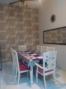 a dining room with a table and four chairs at Homestay Fully Aircond Free Wifi Near MITC,UTEM in Malacca +11 photos