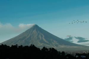 Fj Manila Hotel في Locsin: مجموعة طائرات تطير فوق جبل