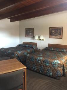 a hotel room with two beds and a table at Lazy U Motel in Rapid City