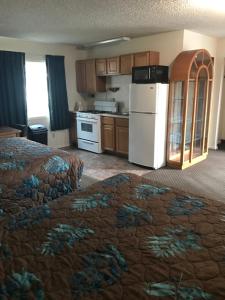 a room with a kitchen with a bed and a refrigerator at Lazy U Motel in Rapid City
