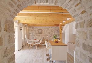 a kitchen and dining room with a stone wall at Villa Sea star in Babino Polje